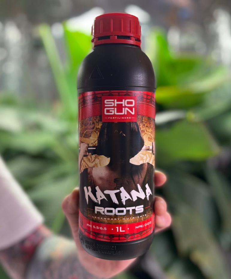 Shogun Katana Roots 1L bottle held in front of green plants